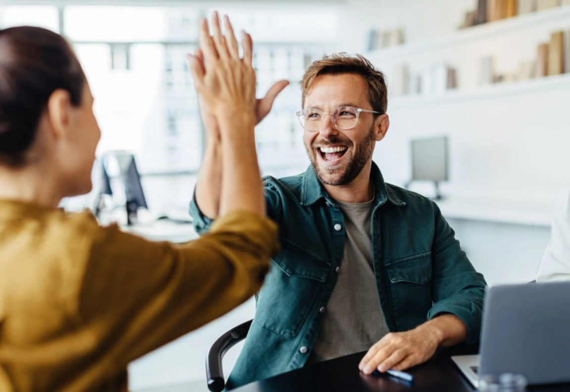 Een bevlogen man geeft zijn collega een high-five.