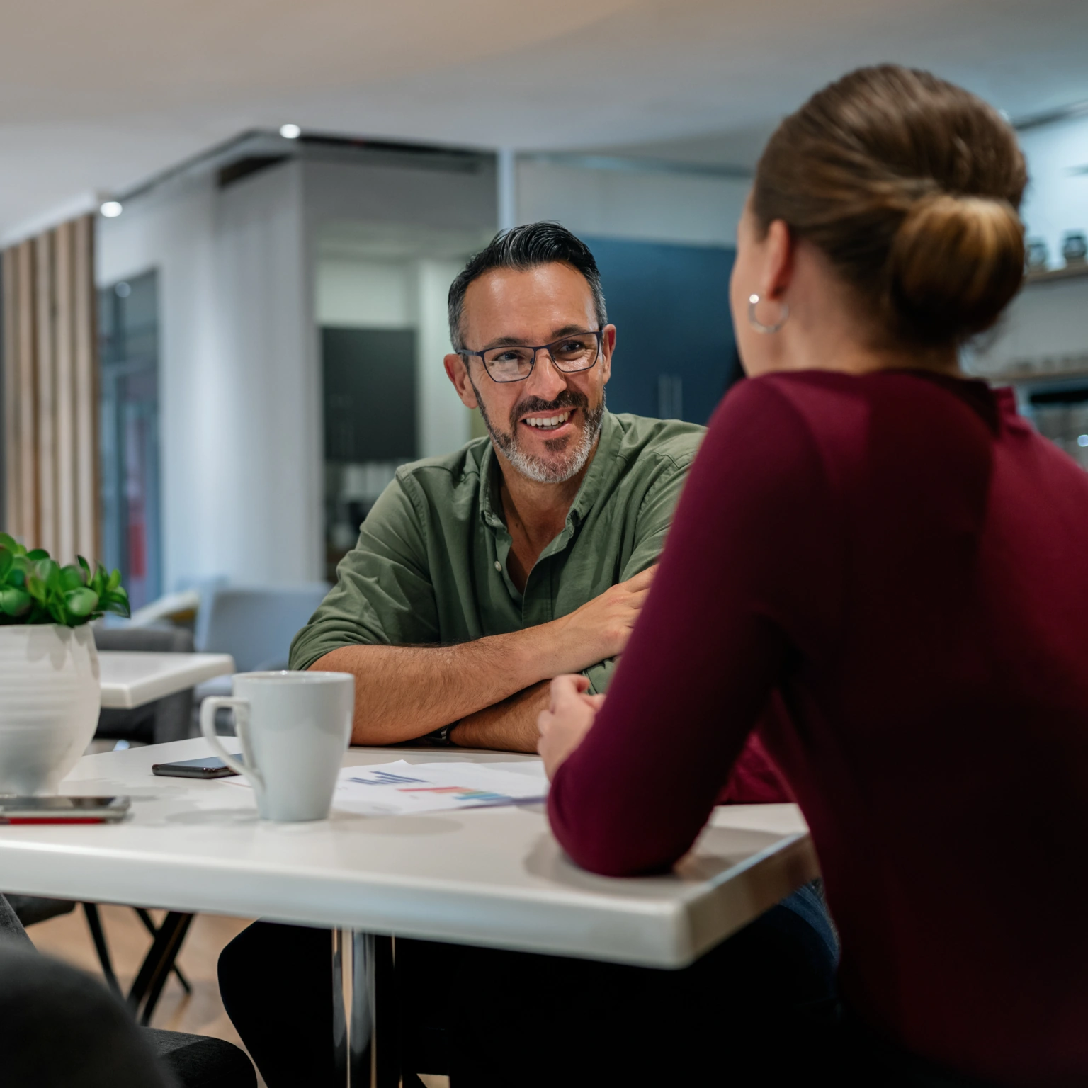 Man en vrouw aan tafel lachend in gesprek.