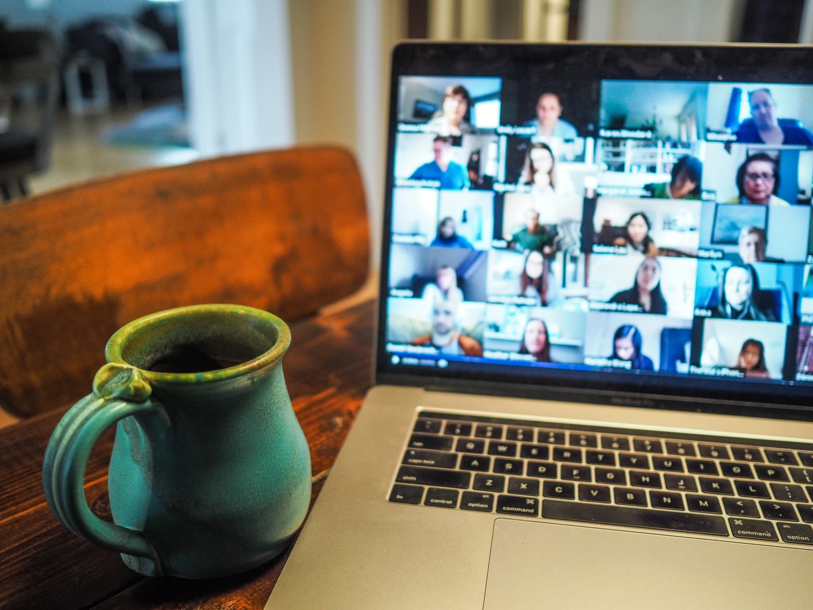 Een laptop waarop een conference call met een groot team bezig is.